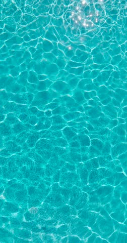 Blue water in the swimming pool with light reflections.