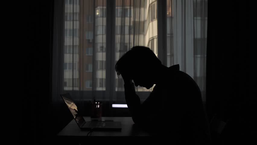 Stressed businessman holding his head while working from home office