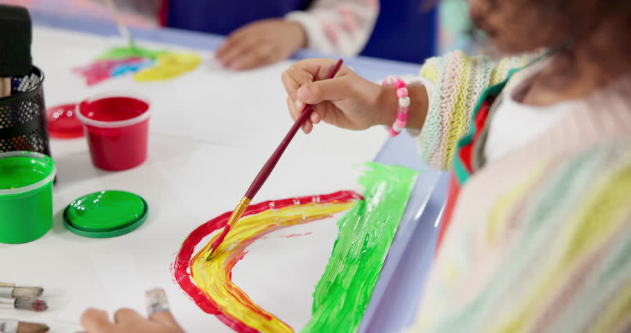 Hands, child and painting art in classroom with creative lesson, drawing rainbow and kindergarten learning. Artist, kid and picture with fun activity, artwork project and motor growth for education