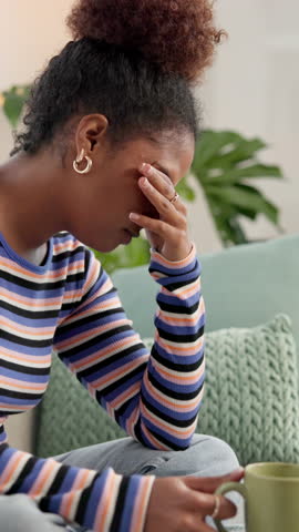 Frustrated, black woman or stress with headache or coffee on sofa for mistake or depression at home. Tired, female person or migraine with anxiety or drink for fatigue, burnout or overworked at house