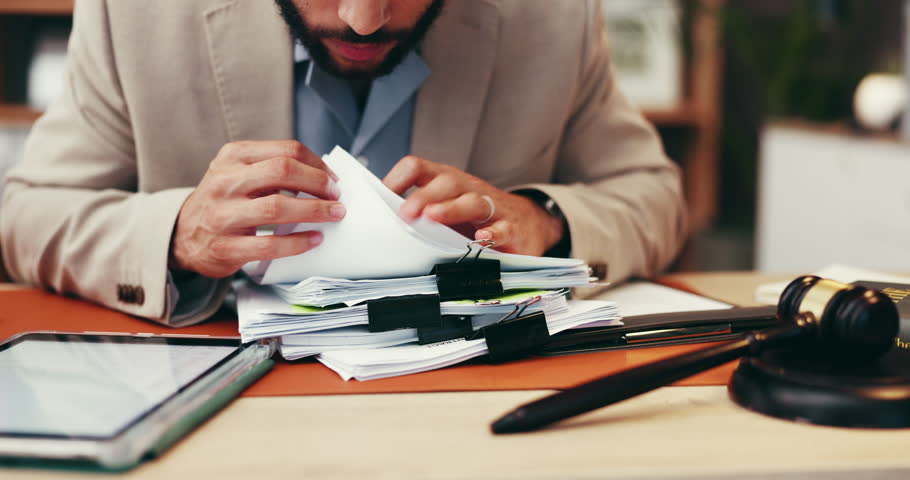 Businessman, hands or lawyer with documents for legal advice, testimonial or statements at office desk. Closeup, man or attorney with paperwork for lawsuit, regulations or case notes at law firm