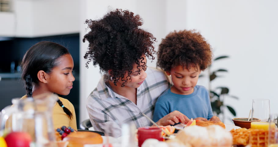 Woman, food and feeding the kids, love and sharing breakfast or eating together. Happy mother and son, nutrition and strawberry for vitamins, healthy meal and fruit or family, wellness and smile