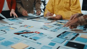 A diverse team collaborates on mobile app design, surrounded by devices and colorful notes. The vibrant workspace reflects creativity and innovation in technology development. SACTR - Powered by Shutterstock - Get 15% off with code: PIKWIZARD15