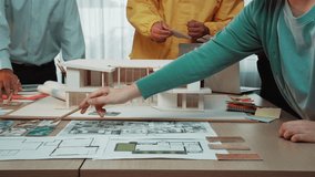 A professional team of architects engages in a collaborative building project, surrounded by blueprints, planning tools, and a detailed 3D model, fostering creativity and teamwork. SACTR - Powered by Shutterstock - Get 15% off with code: PIKWIZARD15