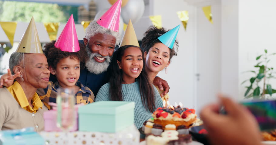 Happy birthday, photo and family with cake, celebration and presents with smile together in dining room. Grandparents, father and children with photography, party and excited with love care in home