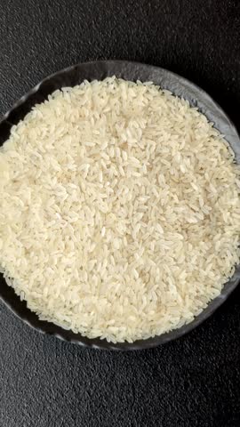 White raw rice in a ceramic bowl. Rice as an ingredient in Asian organic food