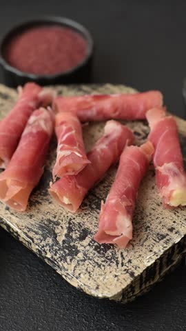 Cheese and meat, jamon or prosciutto rolled into a roll. Antipasti or delicacies for the festive table