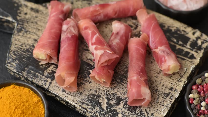 Cheese and meat, jamon or prosciutto rolled into a roll. Antipasti or delicacies for the festive table