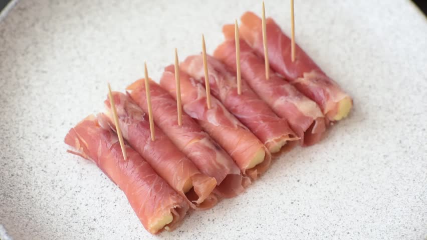 Cheese and meat, jamon or prosciutto rolled into a roll. Antipasti or delicacies for the festive table