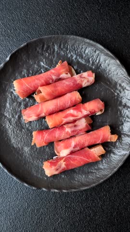 Cheese and meat, jamon or prosciutto rolled into a roll. Antipasti or delicacies for the festive table