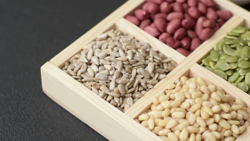 A box of peanuts and cedar nuts and sunflower and pumpkin seeds as ingredients for organic healthy food