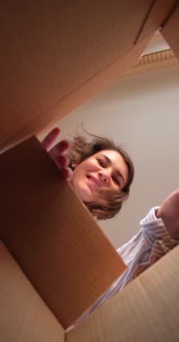 Vertical video of young beautiful woman opens her order in delivery box with online purchase