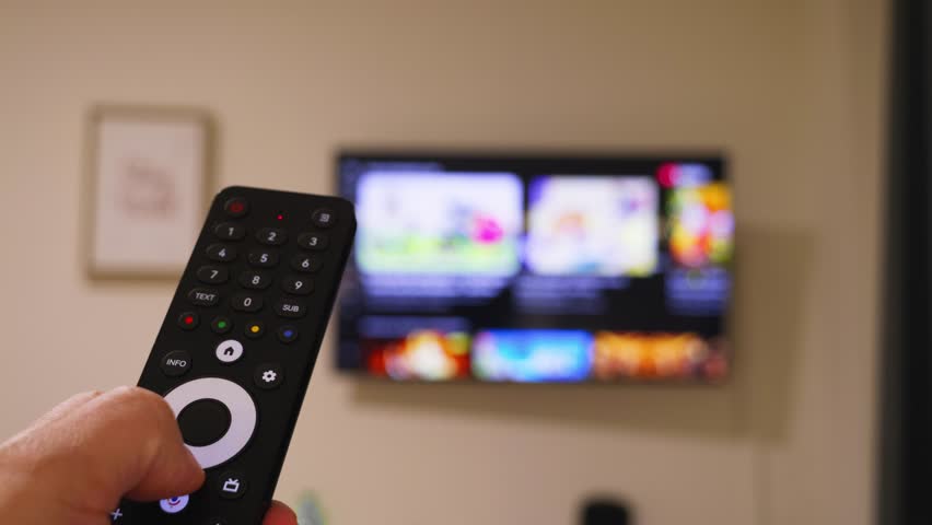 Male hand holding the TV remote control and turn on smart tv. Switching channels. High quality 4k footage