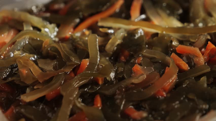 Kelp seaweed texture close up, salad with laminaria and carrot, healthy food concept. High quality 4k footage
