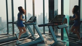 Young woman in sportswear runs on treadmill in gym. Strong sportswoman exercises on modern trainer in inspiring workout environment. Lady enjoys sports activity in urban area - Powered by Shutterstock - Get 15% off with code: PIKWIZARD15