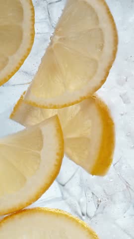 Super Slow Motion of Pouring Mineral Water into Glass with Ice Cubes and Lemons . Filmed on High Speed Cinema Camera , 1000fps