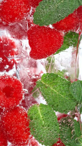 Super Slow Motion of Pouring Mineral Water into Glass with Ice Cubes and Fruit . Filmed on High Speed Cinema Camera , 1000fps