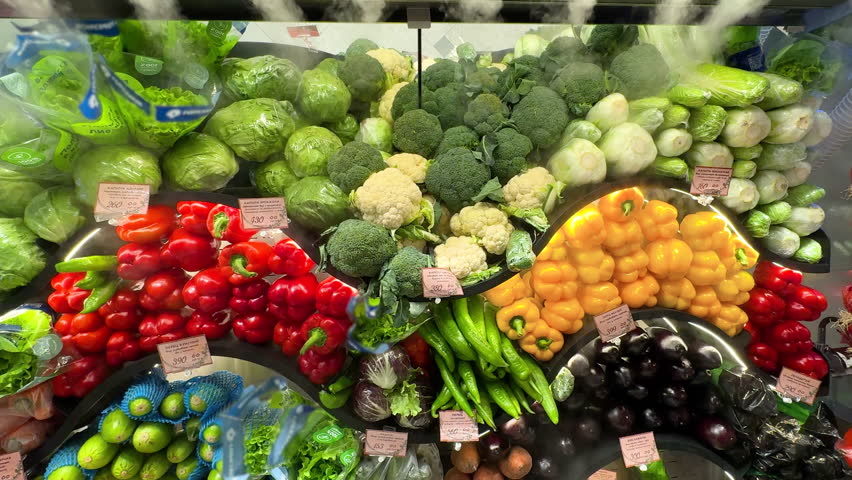 Colorful array of fresh vegetables beautifully arranged in market. Bright red peppers, green lettuce, yellow bell peppers, cauliflowers, cabbages. Display healthy organic produce, nutrition culinary.