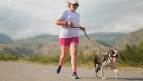 A curvy girl in sportswear struggles up a mountain road, her pit bull panting in the thick pre storm heat. Cloud cover offers brief relief, but each step shows the strain of lingering summer fatigue. - Powered by Shutterstock - Get 15% off with code: PIKWIZARD15