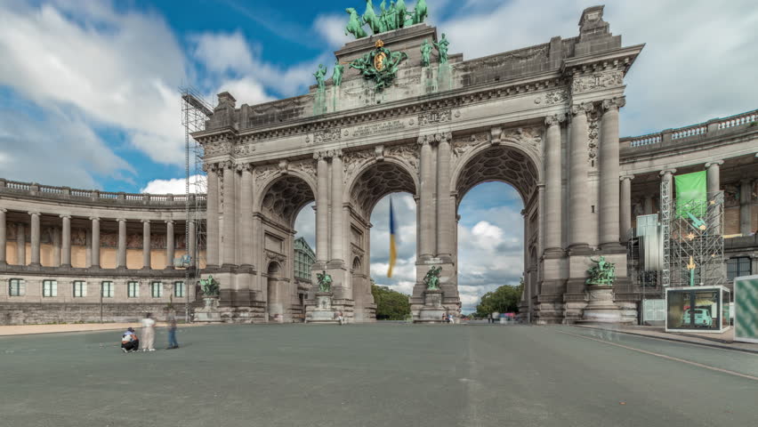 Hyperlapse of the Cinquantenaire Arcade in Jubelpark, Brussels, Belgium. The memorial triumphal arch stands tall under dramatic clouds timelapse, symbolizing Belgian history and independence.