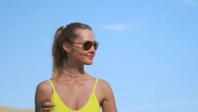 A fit young woman in a yellow top, white bike shorts, and sunglasses walks a pit bull along a desolate mountain road. Dry hills and sparse bushes stretch under bright summer sunlight. - Powered by Shutterstock - Get 15% off with code: PIKWIZARD15