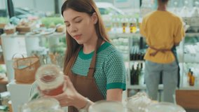 Female owner of zero waste shop doing audit.Person Refilling Containers at a Zero-Waste Store. eco friendly store  - Powered by Shutterstock - Get 15% off with code: PIKWIZARD15