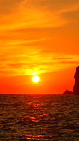 Sunset Ocean Rocks Dramatic Fiery sky over coastal rocks during sunset, showcasing vibrant colors and tranquil ocean.