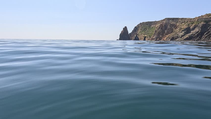 Sea water surface. Low angle view over clear azure sea water. Sun glare. Abstract nautical summer ocean nature. Holiday, vacation and travel concept. Nobody. Slow motion. Weather and climate change