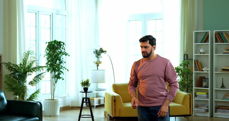 Indian Asian young couple trying to kill mosquitos using a battery-operated electric insect killer racquet in modern living room, fighting mosquito infestation at home with energetic expressions