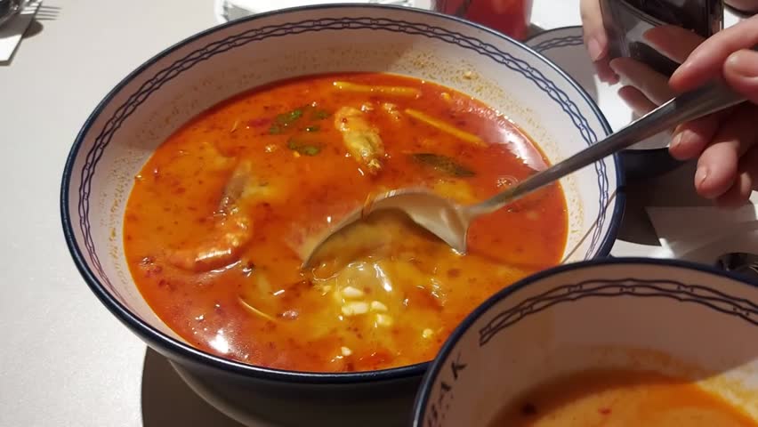 Tom yam kung served in white bowl. Tom yam kung is spicy and sour prawn soup in thai style.