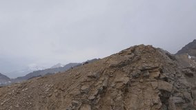 Drone view of hikers trekking along the steep ridges of Cheget mountain, Caucasus region. The barren rocky slopes contrast with the dramatic cloud-covered peaks - Powered by Shutterstock - Get 15% off with code: PIKWIZARD15