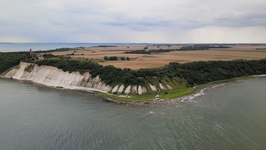 Timelapse drone footage of Rügen’s chalk cliffs showing shifting light over white rock, golden fields and the gently moving sea.