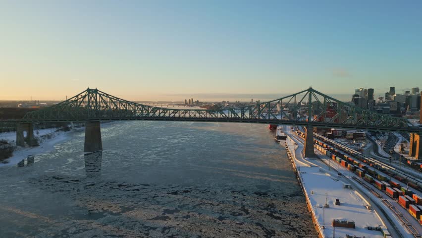 Jacques Cartier bridge spanning the frozen St. Lawrence river in Montreal at sunset, North America, Quebec, Montreal, Canada.