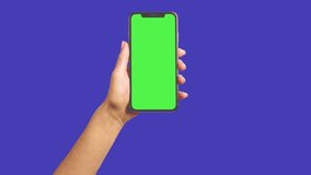 Real human hand swiping on a smartphone with a green screen, chroma key a hand holding mobile animated video 3d render realistic footage, real hand swipes left, scrolling down on online app - Powered by Shutterstock - Get 15% off with code: PIKWIZARD15