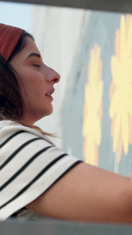 Woman, artist and painting with wall art for mural activity, community service or exterior decoration. Female person, volunteer or painter with brush stroke for floral design, flower or bulding color