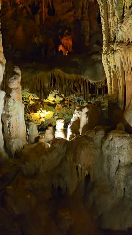 4K footage of incredibly beautiful stalactites and stalagmites in a cave, showcasing stunning natural formations illuminated in a mysterious underground setting

