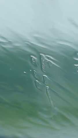 wonderful close view raindrops fall on glass running with water drips reflecting blue and green colours