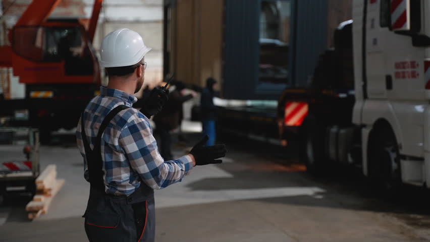 Construction worker coordinating modular home transportation - Powered by Shutterstock - Get 15% off with code: PIKWIZARD15