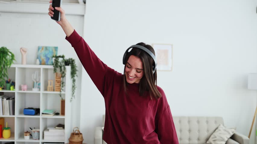 Young woman enjoying music and dancing at home