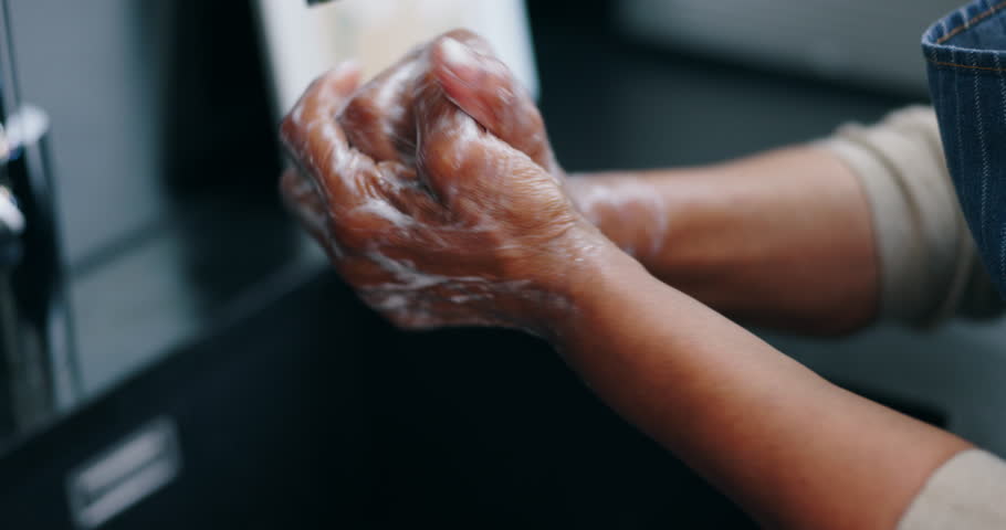 Water, soap and person washing hands in bathroom for skincare safety from germs, dirt and bacteria. Cleaning, hygiene and protection, scrub with foam and rinse fingers with natural skin care in home.