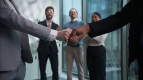 Close up handshake two businesspeople shaking hands background of office multiethnic workers applause businessmen businesswomen team successful business financial deal agreement partners cooperation - Powered by Shutterstock - Get 15% off with code: PIKWIZARD15
