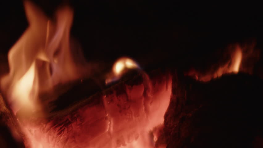 A close-up of firewood igniting with bright, vibrant flames, creating a dynamic and glowing display of fire