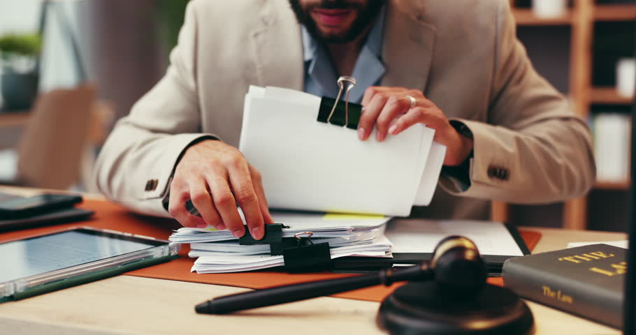 Businessman, hands or judge with paperwork for legal advice, testimonial or statements at office desk. Closeup, lawyer or attorney with documents for lawsuit, regulations or case notes at law firm