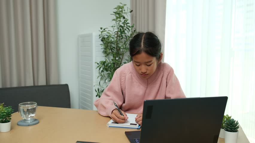 Asian girl diligently studies online and does homework during summer break