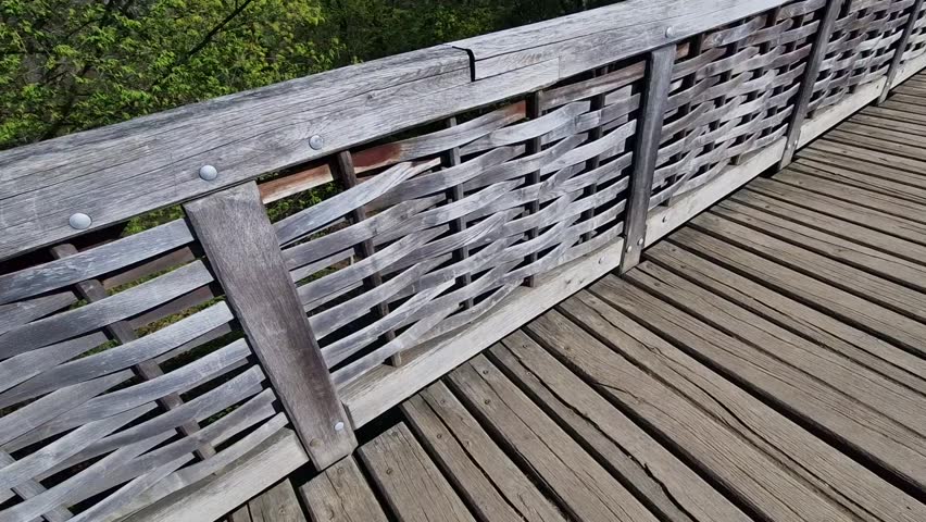 Medieval oak wood, bolted. Bridge over the moat. the railing is made of massive beams, between which several thin oak rods are woven between the vertical warp. Zigzag like knitting a wicker basket.