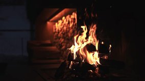 A warm fireplace with vivid flames casting a flickering glow on a stone wall and stacked logs, creating a tranquil and dynamic ambiance. - Powered by Shutterstock - Get 15% off with code: PIKWIZARD15