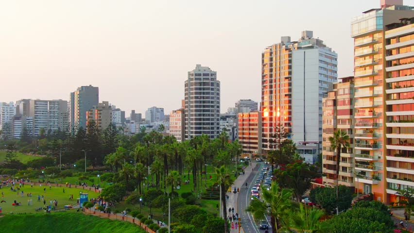 Sunset view of Miraflores skyline with traffic and park in Lima, Peru from above