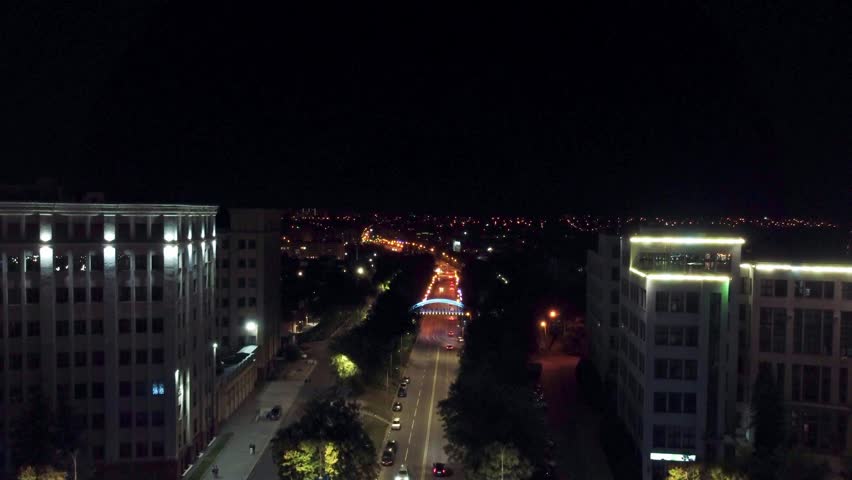 Aerial night illuminated streets dolly footage near Derzhprom, National University buildings and Zoolohichnyy bridge in Kharkiv city, Ukraine