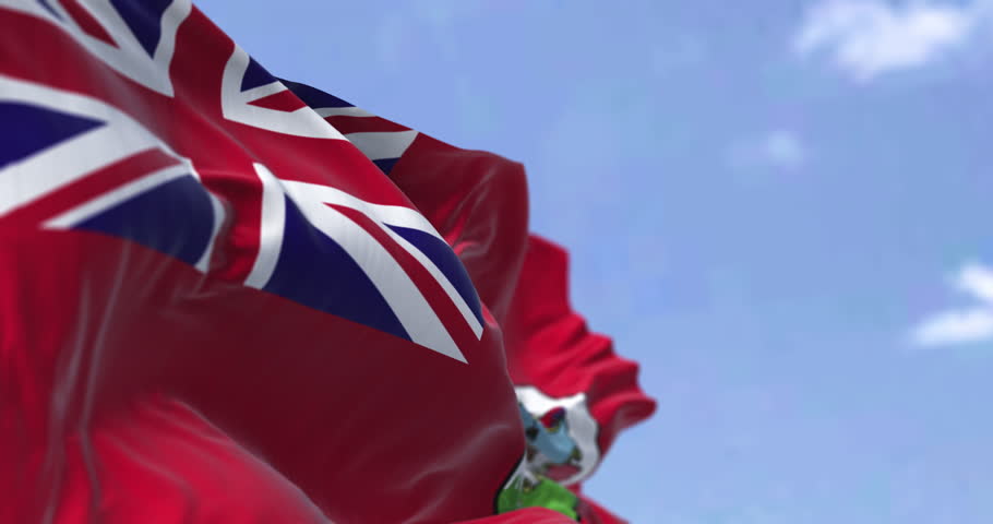Bermudian flag with the Red Ensign and coat of arms, symbolizing pride, identity, and British heritage over the North Atlantic. Seamless 3d render animation. Slow motion loop. Selective focus