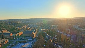 A high drone shot reveals Sheffield's urban sprawl, sun rising over distant hills in morning light. Autumn tones, blue skies, and flowing traffic create a vibrant and serene cityscape. - Powered by Shutterstock - Get 15% off with code: PIKWIZARD15